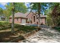 Charming brick home featuring a well-manicured lawn, mature trees, and a welcoming driveway at 7748 Long Bay Pkwy, Catawba, NC 28609