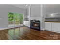 Inviting living room featuring a cozy fireplace, custom built-ins, gleaming wood floors and natural light at 7748 Long Bay Pkwy, Catawba, NC 28609