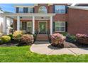 Inviting front porch with elegant columns, seating, and lush landscaping leading to the home's entrance at 9715 Aragorn Nw Ln, Charlotte, NC 28269