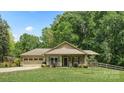 Inviting single-story home with attached two-car garage, complemented by a lush green lawn and mature trees at 10340 Williams Rd, Mint Hill, NC 28227