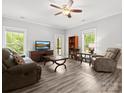 Comfortable living room with neutral walls, ceiling fan, and large windows offering plenty of natural light at 10340 Williams Rd, Mint Hill, NC 28227