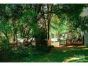 Private backyard with a wooden gate surrounded by lush greenery and mature trees at 106 Friendfield Dr # B, Fort Mill, SC 29715