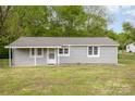 Charming single-story home with gray siding, a covered front porch and well-maintained lawn at 1119 Highway 218 W Hwy, Indian Trail, NC 28079