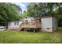 Exterior shot of home featuring a deck and a well-maintained lawn with a brick-lined foundation at 114 Oakland Rd, Belmont, NC 28012