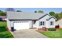 Charming single-story home with a spacious two-car garage, enhanced by well-manicured landscaping in front at 123 Cross Creek Dr, Statesville, NC 28625