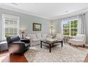 Bright living room featuring hardwood floors, large windows, and neutral décor at 14220 Stewarts Bend Ln, Charlotte, NC 28277