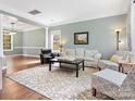 Open-concept living room with hardwood floors, large windows, and elegant décor at 14220 Stewarts Bend Ln, Charlotte, NC 28277