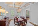 Elegant dining room features coffered ceilings, plantation shutters, chandelier, and ample natural light at 17040 Jetton Rd, Cornelius, NC 28031