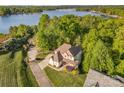 Stunning aerial view showcases the home's proximity to the lake, surrounded by lush greenery and a meticulously maintained lawn at 1713 Mt Isle Harbor Dr, Charlotte, NC 28214