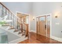 Welcoming foyer with a grand wooden door, hardwood floors, and staircase; enhanced by decorative lighting and neutral paint at 1713 Mt Isle Harbor Dr, Charlotte, NC 28214