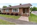 Well-maintained brick home features brick stairs and white railing leading to the front door at 182 Ryan St, Salisbury, NC 28144