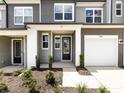 Stylish townhome entrance featuring a covered porch, modern door, and landscaping at 2021 Endeavor Run, Charlotte, NC 28269