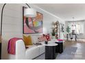 Stylish living room with a white sofa, colorful artwork, and a dining area in the background at 2021 Endeavor Run, Charlotte, NC 28269