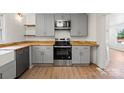 Updated kitchen featuring modern appliances, wood countertops, and sleek gray cabinetry at 300 N Ervin Ave, Newton, NC 28658
