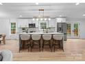 Bright, modern kitchen featuring an island with barstool seating and stainless steel appliances at 3417 Chilham Pl, Charlotte, NC 28226