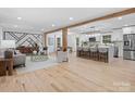 Spacious living space with light wood floors seamlessly flowing into the adjacent open kitchen at 3417 Chilham Pl, Charlotte, NC 28226