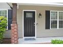Close-up of the black front door with glass detailing and brick pillar at 379 Maiden Sw Ln, Concord, NC 28025