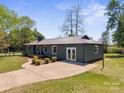 Aerial view of cozy home with a metal roof, front porch, a driveway, and green grass at 4115 Conley St, Newton, NC 28658