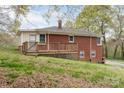 Brick home with a wood deck overlooking the yard and walk-out basement at 668 Riverside Dr, Lincolnton, NC 28092