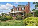 Attractive brick home featuring a covered front porch with columns and lush green lawn at 901 Central Dr, Kannapolis, NC 28083