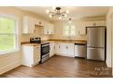 Well-lit kitchen featuring stainless steel appliances, white cabinets, and wood-style flooring at 905 Gantt St, Kings Mountain, NC 28086