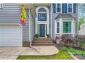 Inviting front entrance with a navy door, arched window, and landscaped garden at 9517 Harris Glen Dr, Charlotte, NC 28269