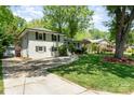 Exterior of a beautiful home featuring mature trees, a well-maintained lawn, and a paved driveway at 1043 Nancy Dr, Charlotte, NC 28211