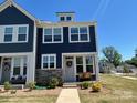 Inviting two-story townhome featuring dark siding, stone accents, and a well-maintained front yard at 1075 South Point Rd, Belmont, NC 28012