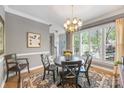 Dining room with a black table and seating for five, illuminated by a decorative chandelier at 110 River Wood Dr, Fort Mill, SC 29715