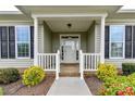 A covered front porch with white railing and landscaping welcomes you to the home at 11123 Bailey Park Nature Dr, Cornelius, NC 28031