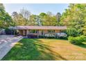 Attractive brick home with a carport, lush lawn, and vibrant flower beds at 113 Princess Ln, Dallas, NC 28034