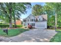 Traditional white home with a long driveway, lush green lawn and mature trees at 1202 Foxfield Rd, Waxhaw, NC 28173