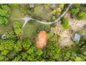 High aerial view of a wooded property with a winding gravel drive, barn, and small outbuilding at 124 Neumann Run, Belmont, NC 28012
