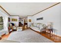 Bright living room with hardwood floors, a cozy couch, and ample natural light from a large window at 124 Neumann Run, Belmont, NC 28012