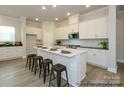 Modern kitchen features an island with bar seating, white cabinets, and stainless steel appliances at 1334 Idyllic Ln, Waxhaw, NC 28173