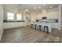 Spacious kitchen with an island with bar seating, white cabinets, stainless appliances, and hardwood floors at 1334 Idyllic Ln, Waxhaw, NC 28173