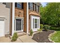 Close-up of front entrance featuring brick accents, white columns, and manicured landscaping at 15002 Strathmoor Dr, Charlotte, NC 28277