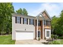 Inviting two-story home with brick and vinyl exterior, attached two-car garage, and manicured front yard at 15002 Strathmoor Dr, Charlotte, NC 28277