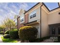 Charming townhome displaying neutral siding and brick accents, complemented by manicured bushes and lush green lawn at 1716 Termini Dr, Charlotte, NC 28262