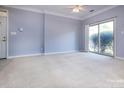 Bright living room boasting neutral paint, carpeted floors, a ceiling fan, and sliding glass doors at 1716 Termini Dr, Charlotte, NC 28262