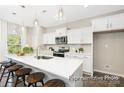 Bright kitchen features white cabinets, stainless steel appliances, an eat-in island, and pendant lighting at 2414 Morgan Hills Dr # 296P, Albemarle, NC 28001