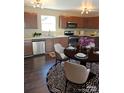 Eat-in kitchen featuring stainless steel appliances, granite countertops, and hardwood flooring at 2440 Mint Thistle Ct, Charlotte, NC 28269