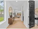 Bright entryway with wood floors, a decorative mirror, and a view into the living area at 3256 Brixton Ct, Charlotte, NC 28205