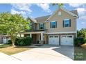 Inviting home featuring stone accents, a two-car garage, and a well-maintained lawn at 3912 Franklin Meadows Dr, Matthews, NC 28105