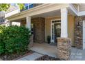 Welcoming front porch featuring stone pillars and accents, providing a charming entrance to the home at 3912 Franklin Meadows Dr, Matthews, NC 28105