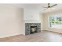 Cozy living room features a stone fireplace, wood floors, and natural light from the window at 5162 Beckenham Ln, Concord, NC 28025