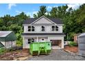 Two-story home showing gray siding, black roof and a green construction dumpster sitting in front at 530 Gantt St, Mooresville, NC 28115