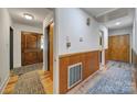 Inviting hallway with wood-paneled walls, a closet, and stylish flooring leading to a front door at 5938 Mundy Rd, Denver, NC 28037