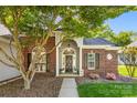 Close-up of the front door of a brick home with beautiful landscaping and a welcoming entrance at 6002 Sentinel Dr, Indian Trail, NC 28079