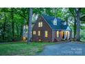 View of the rear of the home showing driveway, mature trees, and access to additional living space at 625 4Th Street Nw Dr, Hickory, NC 28601